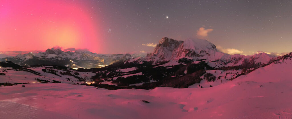 Aurora Boreale sulle Dolomiti: Un Incantevole Spettacolo Rosa colora le Montagne Patrimonio dell’Umanità