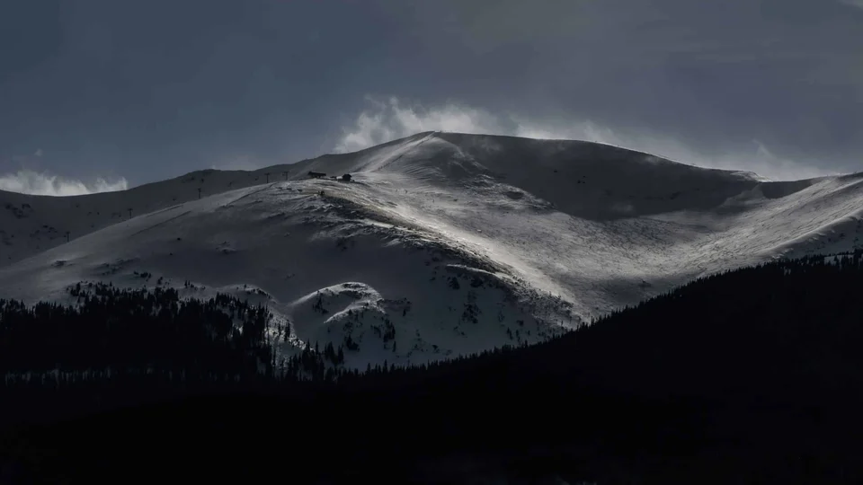 Panorama di un comprensorio sciistico innevato con impianti e boschi